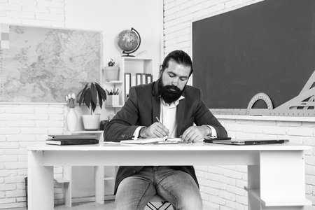 concentrated on work. male student sit in school classroom while lesson. pass the exam. learning the...