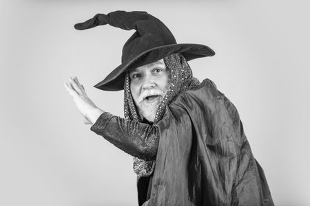 Weird old grandfather with gray beard. Devil man. Holiday and celebration. Magic hat. Best ideas for Halloween. Halloween party. witch man in hat and cloak. happy halloweenの写真素材