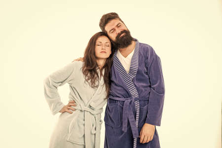 Tired couple of man and woman stand sleeping in cozy robes isolated on white, asleepの写真素材
