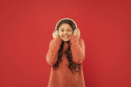 listening audio book. glad child listen music in headphones. kid wear sweater.