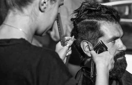 brutal guy with barbershop professional master use electric shaver. hipster. male barber care. bearded man at hairdresser chair in salon. beauty and fashion. hair and beard. Fresh funky beautyの写真素材