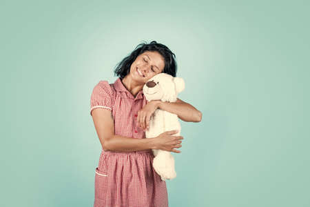 feeling of love. female hold present. toy shop concept. happy woman hold bear. girl in vintage dress. retro fashion style. attractive beauty with brunette hair play with toy. express human emotionsの写真素材