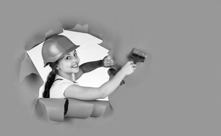 Trust me I am an expert. kid wear helmet on construction site. teen girl painter with painting brush...