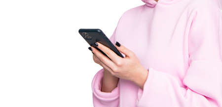Woman crop view in casual pink hoodie using smartphone isolated on white, social networkingの写真素材