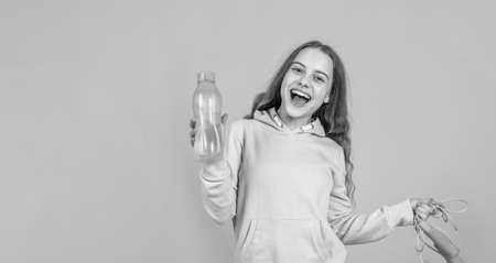happy smiling child girl hold sport or fitness equipment of jumping rope and water bottle, healthの写真素材