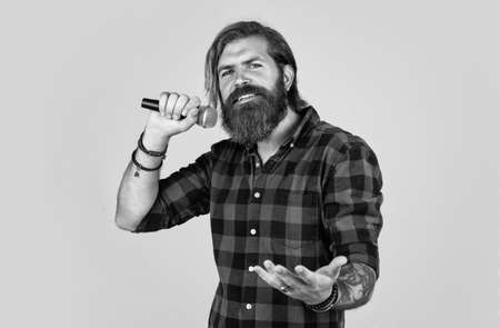 brutal caucasian hipster with beard in shirt sing in karaoke, musicの写真素材