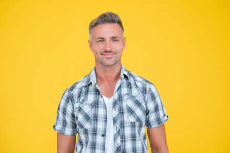 happy mature man with grizzle hair on yellow backgroundの写真素材