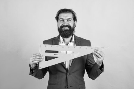 Teacher man with happy face holding triangle ruler, back to school concept