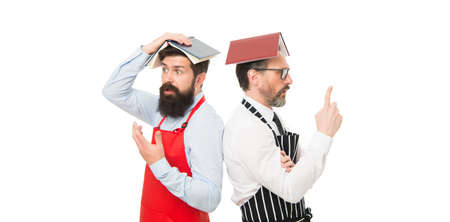 puzzled men husband learn cooking. Culinary school. catering business. seating plan. bearded men with recipe book. menu planning. happy chef team in apron. cafe and restaurant opening. Chef at workの写真素材