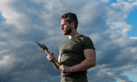man with axe. caucasian man hold ax. brutal man on dramatic sky backgroundの写真素材