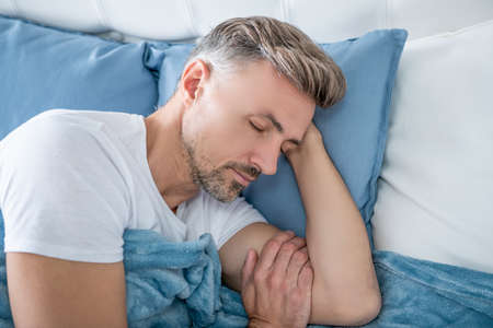 mature man relax in bed. early morningの写真素材