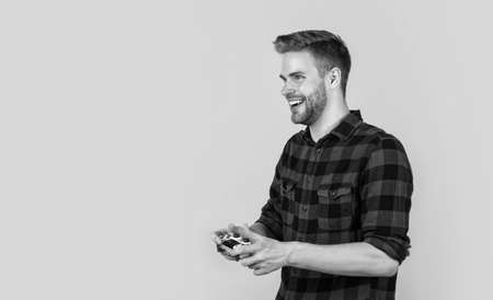 stylish guy with trendy hairstyle wear checkered shirt playing video game, fun