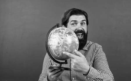 cheerful bearded man in checkered shirt holding geographic globe, geography school education