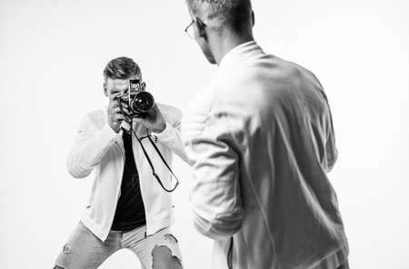 young twin brothers photographer with similar appearance make photo with retro camera, photographingの写真素材