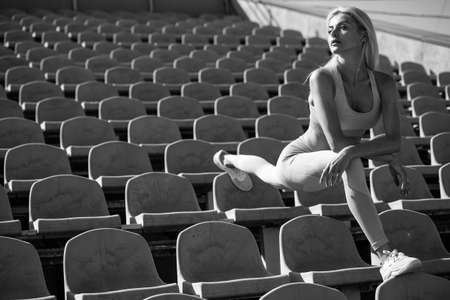 female sport athlete in sportswear on stadium training fitness, stretchingの写真素材