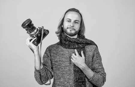 photographer man with long hair hold photo camera wear knitted sweater and scarf, photographingの写真素材