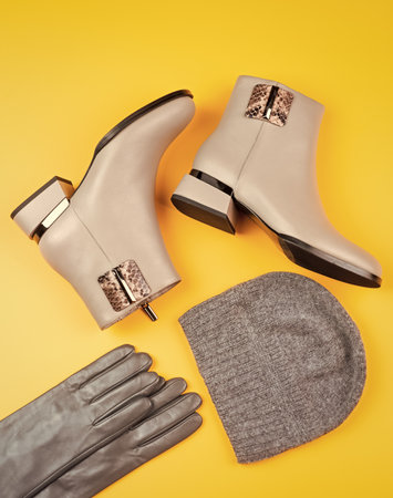 fashion accessory. pair of fashionable leather shoes and hat. beige boots and gloves.