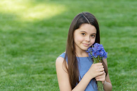 teen girl with flowers. pretty girl on grass. cute girl portrait. copy spaceの写真素材