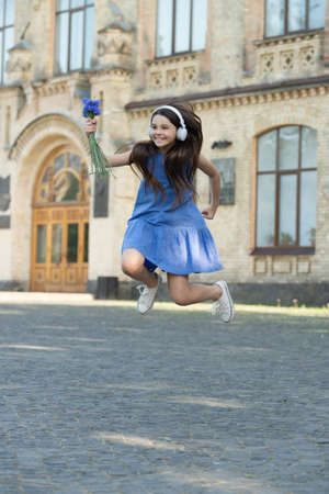 positive teen girl in headphones. girl jump outdoor. carefree girl jumping feel happinessの写真素材