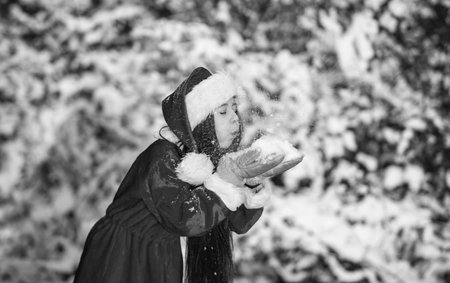 Happiness and joy. Kid santa hat. Gifts from Santa. Frosty christmas morning. Santa Claus. Sunny winter day. Child happy girl outdoors snowy nature. Merry christmas. Happy childhood conceptの写真素材