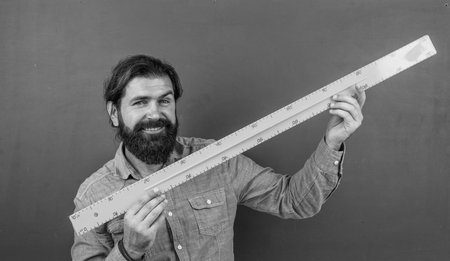 prepare for exam. college lecturer on geometry lesson. back to school. formal education. knowledge day. mature bearded teacher use math ruler tools. brutal man work in classroom with blackboardの写真素材