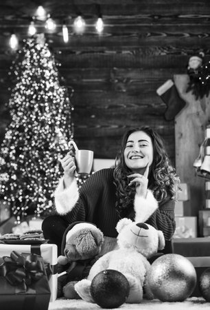 Decorate home. Xmas spirit. Winter sale. Celebrate holiday. Holiday tradition. Santa is near. Happy girl at christmas tree. Family holiday celebration. Happy new year. Woman enjoy cozy atmosphereの写真素材