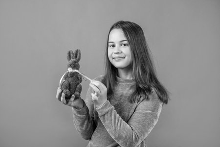 cute child girl hold easter rabbit from green grass for egg hunt, happy easterの写真素材