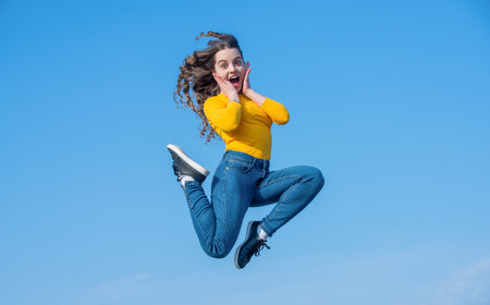 amazed teen girl jump high on sky backgroundの写真素材