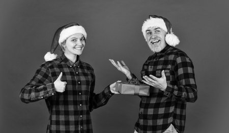 Surprise for spouse. Buy present. Christmas party. Couple in love with gift. Christmas time. Man and woman christmas holiday celebration. Giving present. Love and care. Spread love. Family shoppingの写真素材