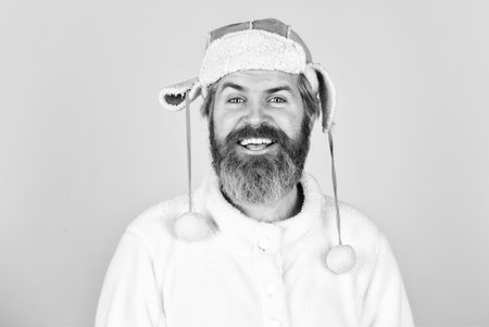 Christmas atmosphere around. man beard in winter hat. portrait of trendy guy in hat. Male winter style. Modern winter earflap beanie hat. Funky happy bearded man. mature man posing with funny outfitの写真素材