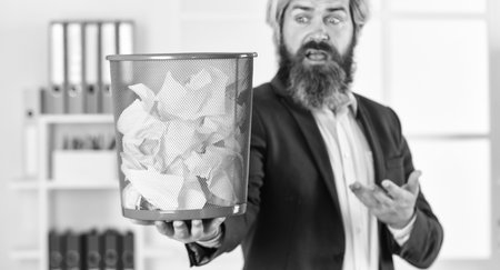 businessman hold full paper bin with crumpled papers. business and trash. man search crimpled paper in basket. ceo in messy office. throw garbage into paper container. selective focusの写真素材