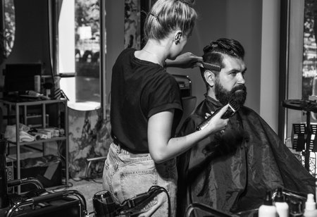 mature caucasian guy visiting barbershop brings a beard and hair in order with the help of a hairdresser, Self-care, masculine beautyの写真素材