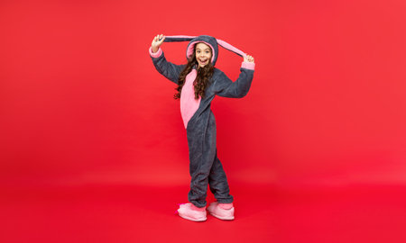 amazed teen girl in soft night suit standing on red background, bedtimeの写真素材