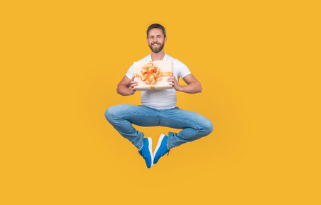 Delivery man hovering with gift box in midair. Happy man levitating with present box. Deliveryの写真素材