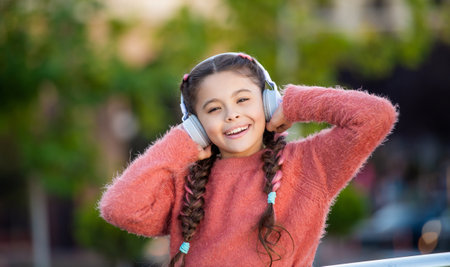 Happy girl listening to music. Teenage girl smiling while listening to headphonesの写真素材