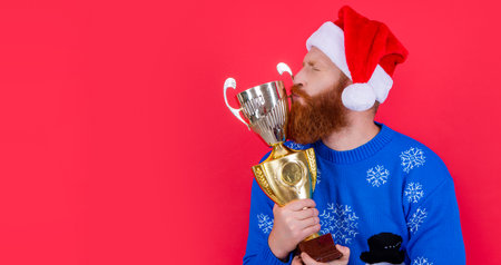 new year goal and win. man win a goal in new year. kiss the trophy. man has goal in new yearの写真素材