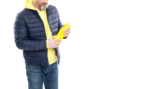 cropped view of man with water bottle in studio. bottle in hands of man. bottle for water held by...