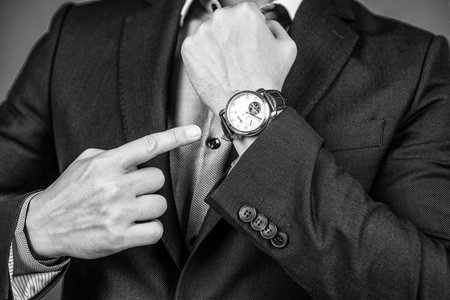 Wearing watch with outfit. Blue suit and wristwatch on male hand cropped view.