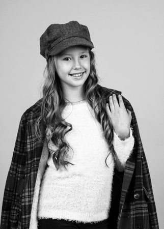 teen girl with long curly hair wear trendy hat and checkered jacket, french fashionの写真素材