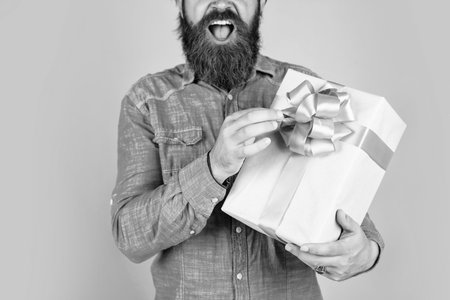 surprise for him. shopping and sale. mature brutal hipster with present. buy in mall. happy bearded man holding gift box. happy birthday or anniversary. holiday celebrationの写真素材