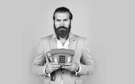 Feel the connection. elegant businessman has business talk. communication. true gentleman with groomed hair hold vintage telephone. nice conversation. bearded man in formalwear speak on retro phoneの写真素材