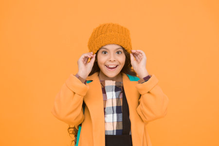 Winter hat accessory. Girl long hair yellow background. Cold season concept. Winter fashion...