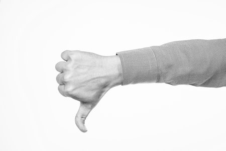 Thumbs down. dislike or unlike gesture. denote something bad. male hand with thumb down.の写真素材