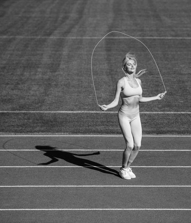 energetic woman athlete jumping on skipping rope warm up do sport workout, physical training.の写真素材