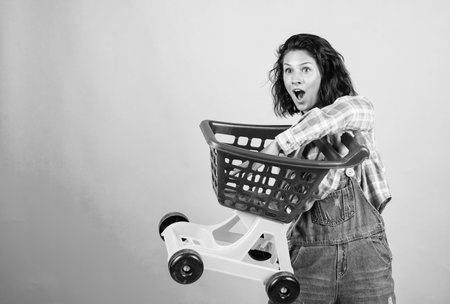 woman shopping in supermarket pushing trolley. happy girl hold shopping cart. Buyer in supermarket. customer with empty cart. female shopper with trolley in supermarketの写真素材