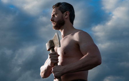 shirtless man with axe. brutal caucasian man hold ax. brutal man on sky backgroundの写真素材