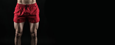 cropped view of sportsman quadriceps. fitness sportsman with quadriceps isolated on black.の写真素材