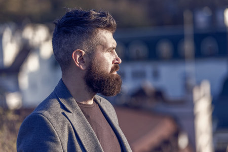 His bearded hair look styled. Bearded man outdoor. Bearded hipster in casual business style. Brutal guy wear mustache and beard on bearded face. Barbershop. Beard groomingの写真素材