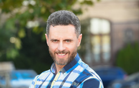 His haircut compliments his barber. Happy guy on urban background. Bearded man with shaped beard....