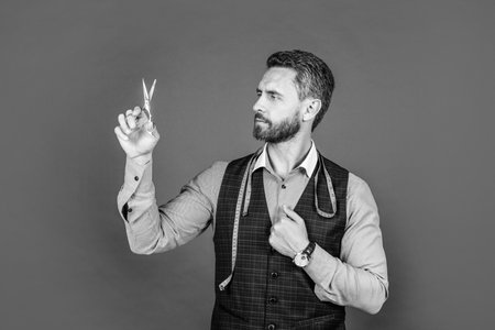 professional tailor with scissors and measuring tape. fashion designer. man individual tailoring.
